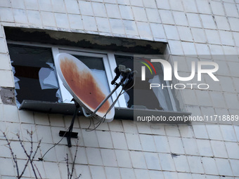 A satellite dish is next to a shattered window at an apartment block in the Solomianskyi district damaged by a Russian drone attack in Kyiv,...