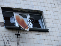 A satellite dish is next to a shattered window at an apartment block in the Solomianskyi district damaged by a Russian drone attack in Kyiv,...