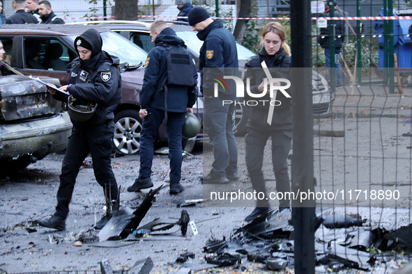 Law enforcers pick up the fragments of a Russian UAV in the Solomianskyi district after a Russian drone attack in Kyiv, Ukraine, on October...