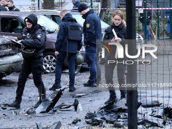 Law enforcers pick up the fragments of a Russian UAV in the Solomianskyi district after a Russian drone attack in Kyiv, Ukraine, on October...