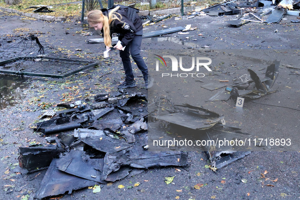 A police officer studies the fragments of a Russian UAV in the Solomianskyi district after a Russian drone attack in Kyiv, Ukraine, on Octob...