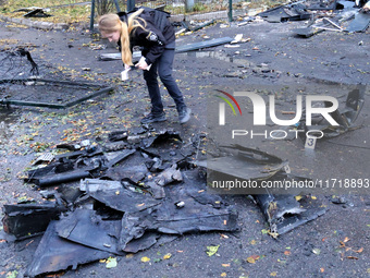 A police officer studies the fragments of a Russian UAV in the Solomianskyi district after a Russian drone attack in Kyiv, Ukraine, on Octob...