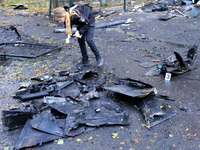 A police officer studies the fragments of a Russian UAV in the Solomianskyi district after a Russian drone attack in Kyiv, Ukraine, on Octob...