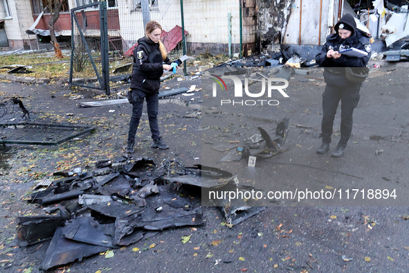 Law enforcers pick up the fragments of a Russian UAV in the Solomianskyi district after a Russian drone attack in Kyiv, Ukraine, on October...