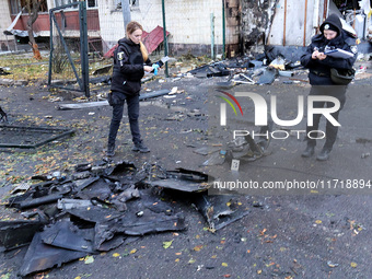 Law enforcers pick up the fragments of a Russian UAV in the Solomianskyi district after a Russian drone attack in Kyiv, Ukraine, on October...