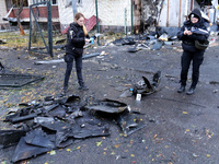 Law enforcers pick up the fragments of a Russian UAV in the Solomianskyi district after a Russian drone attack in Kyiv, Ukraine, on October...