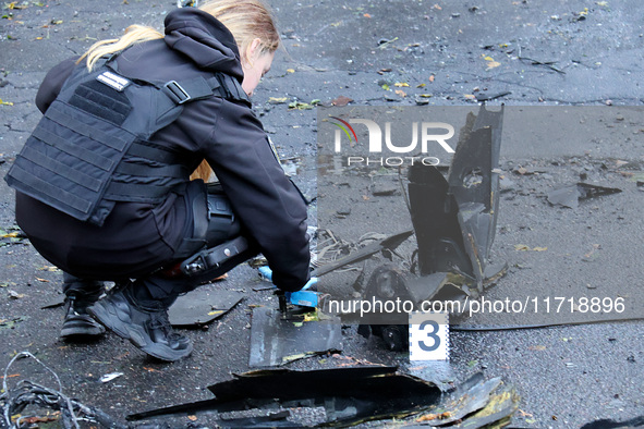 A police officer studies the fragments of a Russian UAV in the Solomianskyi district after a Russian drone attack in Kyiv, Ukraine, on Octob...