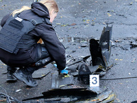 A police officer studies the fragments of a Russian UAV in the Solomianskyi district after a Russian drone attack in Kyiv, Ukraine, on Octob...