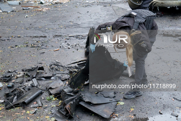 A police officer studies the fragments of a Russian UAV in the Solomianskyi district after a Russian drone attack in Kyiv, Ukraine, on Octob...