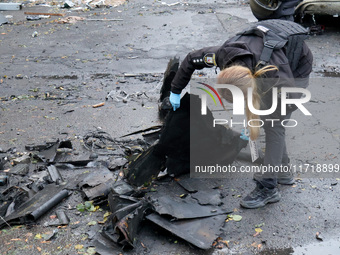 A police officer studies the fragments of a Russian UAV in the Solomianskyi district after a Russian drone attack in Kyiv, Ukraine, on Octob...