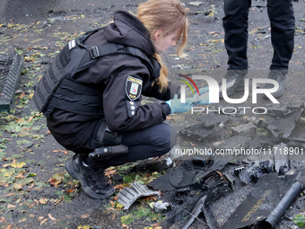 A police officer studies the fragments of a Russian UAV in the Solomianskyi district after a Russian drone attack in Kyiv, Ukraine, on Octob...