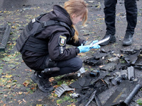 A police officer studies the fragments of a Russian UAV in the Solomianskyi district after a Russian drone attack in Kyiv, Ukraine, on Octob...