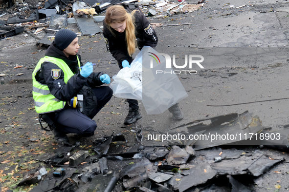 Law enforcers pick up the fragments of a Russian UAV in the Solomianskyi district after a Russian drone attack in Kyiv, Ukraine, on October...