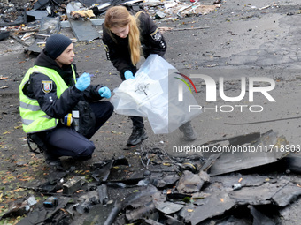 Law enforcers pick up the fragments of a Russian UAV in the Solomianskyi district after a Russian drone attack in Kyiv, Ukraine, on October...