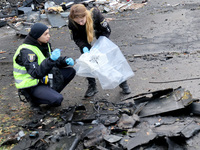 Law enforcers pick up the fragments of a Russian UAV in the Solomianskyi district after a Russian drone attack in Kyiv, Ukraine, on October...