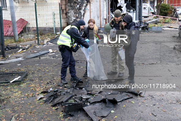 Law enforcers pick up the fragments of a Russian UAV in the Solomianskyi district after a Russian drone attack in Kyiv, Ukraine, on October...