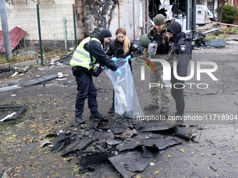 Law enforcers pick up the fragments of a Russian UAV in the Solomianskyi district after a Russian drone attack in Kyiv, Ukraine, on October...