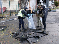 Law enforcers pick up the fragments of a Russian UAV in the Solomianskyi district after a Russian drone attack in Kyiv, Ukraine, on October...