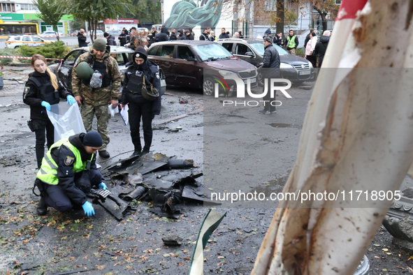 Law enforcers pick up the fragments of a Russian UAV in the Solomianskyi district after a Russian drone attack in Kyiv, Ukraine, on October...