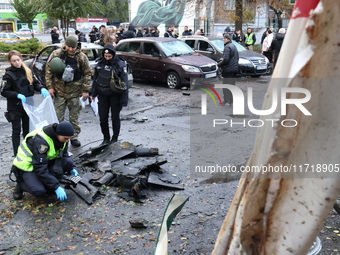 Law enforcers pick up the fragments of a Russian UAV in the Solomianskyi district after a Russian drone attack in Kyiv, Ukraine, on October...