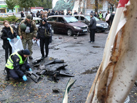 Law enforcers pick up the fragments of a Russian UAV in the Solomianskyi district after a Russian drone attack in Kyiv, Ukraine, on October...