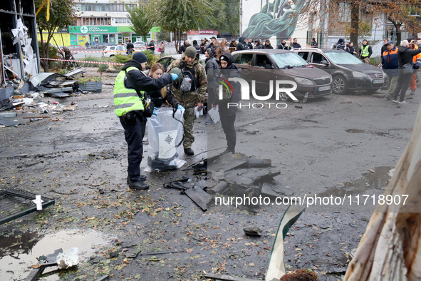 Law enforcers pick up the fragments of a Russian UAV in the Solomianskyi district after a Russian drone attack in Kyiv, Ukraine, on October...