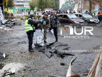 Law enforcers pick up the fragments of a Russian UAV in the Solomianskyi district after a Russian drone attack in Kyiv, Ukraine, on October...