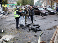 Law enforcers pick up the fragments of a Russian UAV in the Solomianskyi district after a Russian drone attack in Kyiv, Ukraine, on October...