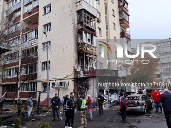 Onlookers stand outside an apartment block in the Solomianskyi district damaged by a Russian drone attack in Kyiv, Ukraine, on October 29, 2...