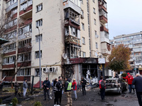 Onlookers stand outside an apartment block in the Solomianskyi district damaged by a Russian drone attack in Kyiv, Ukraine, on October 29, 2...