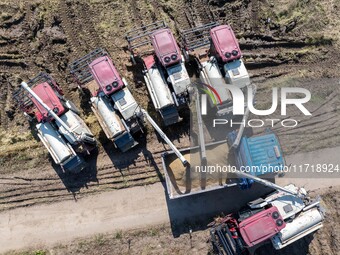 Workers operate machines to harvest rice at Baima Lake farm in Huai'an, China, on October 29, 2024. (