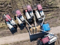 Workers operate machines to harvest rice at Baima Lake farm in Huai'an, China, on October 29, 2024. (