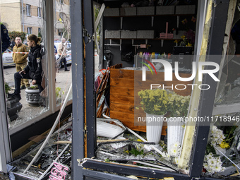 A woman inspects the damage to a flower shop after a Russian drone strike in Kyiv, Ukraine, on October 29, 2024 (