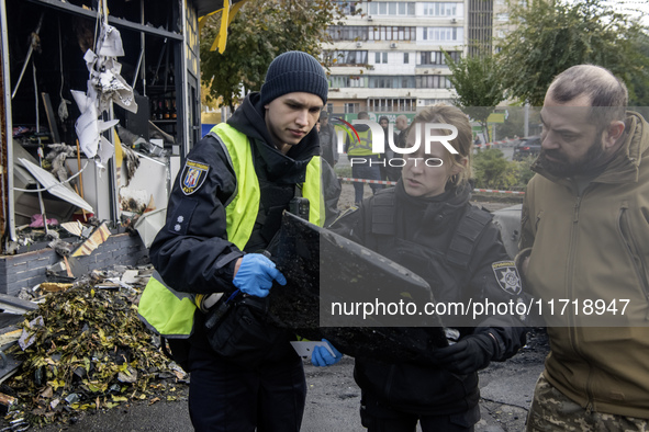 Experts inspect a part of a Russian Shahed at the site of a Russian drone strike near a residential building in Kyiv, Ukraine, on October 29...