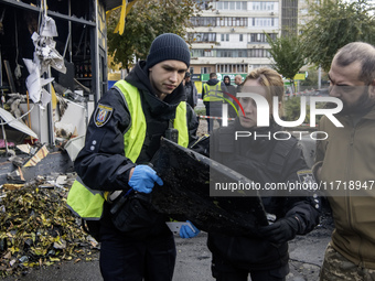 Experts inspect a part of a Russian Shahed at the site of a Russian drone strike near a residential building in Kyiv, Ukraine, on October 29...