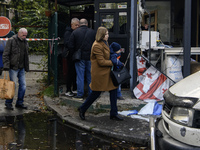 A woman carries a child near the site of a Russian drone strike close to a residential building in Kyiv, Ukraine, on October 29, 2024 (