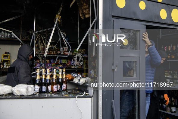 People clean up the damage to a product shop after a Russian drone strike in Kyiv, Ukraine, on October 29, 2024 