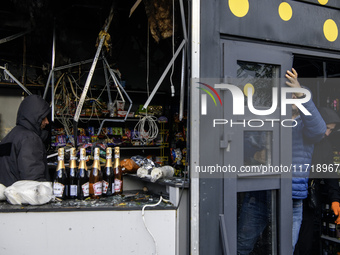 People clean up the damage to a product shop after a Russian drone strike in Kyiv, Ukraine, on October 29, 2024 (