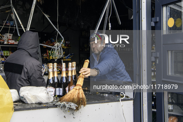 People clean up the damage to a product shop after a Russian drone strike in Kyiv, Ukraine, on October 29, 2024 