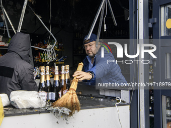 People clean up the damage to a product shop after a Russian drone strike in Kyiv, Ukraine, on October 29, 2024 (