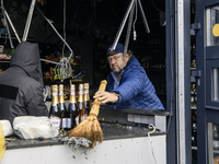 People clean up the damage to a product shop after a Russian drone strike in Kyiv, Ukraine, on October 29, 2024 (