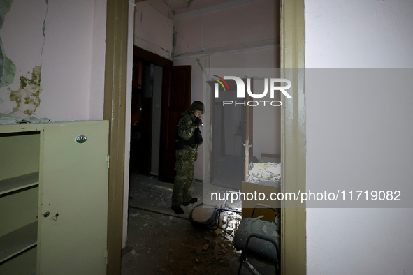 A law enforcer examines the 1930s Derzhprom building damaged by a Russian guided bomb in central Kharkiv, Ukraine, on October 28, 2024. NO U...