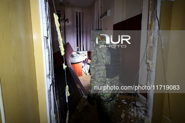 A law enforcer examines the 1930s Derzhprom building damaged by a Russian guided bomb in central Kharkiv, Ukraine, on October 28, 2024. NO U...