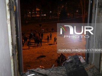 A shattered window frames people in the street outside the 1930s Derzhprom building, which a Russian guided bomb damages in central Kharkiv,...