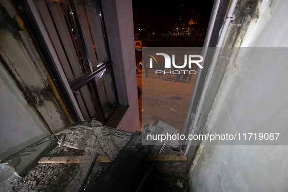 A shattered window frames people in the street outside the 1930s Derzhprom building, which a Russian guided bomb damages in central Kharkiv,...