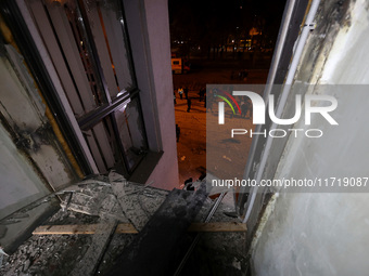 A shattered window frames people in the street outside the 1930s Derzhprom building, which a Russian guided bomb damages in central Kharkiv,...