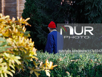 A man in a red hat and denim jacket stands in the square near the Golden Gate in Kyiv, Ukraine, on October 28, 2024. (