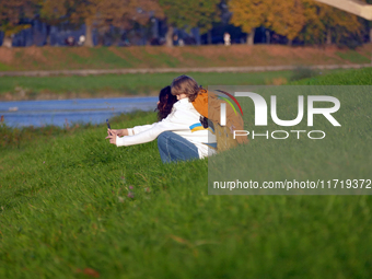 In Uzhhorod, Ukraine, on October 27, 2024, a woman and child take a selfie on the bank of the Uzh River, Uzhhorod, Zakarpattia region, weste...