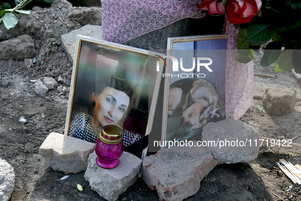 The photographs of a woman and her dog are outside a residential building destroyed by the Russian missile attack in the Novokodatskyi distr...