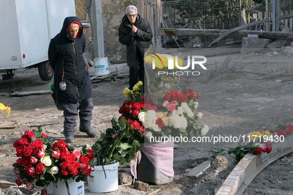 Elderly women stand in front of a floral tribute to the victims of the Russian missile attack that occurs in the Novokodatskyi district in t...